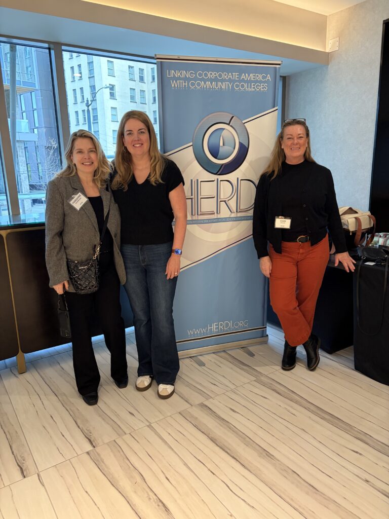 ACUE client partners with the HERDI sign. 